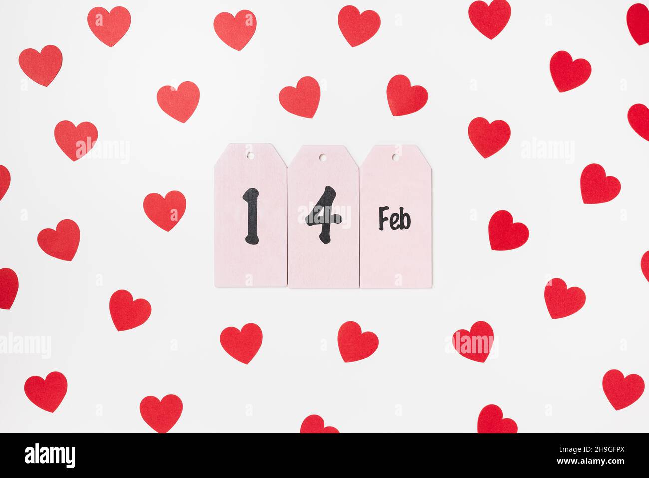 Romantico backround con testo 14 Feb e carta rossa confetti cuori su bianco. Concetto di festa di San Valentino, appartamento vacanza Foto Stock