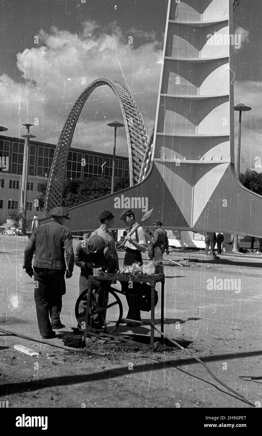 Wroc³aw, 1948-07. Przygotowania do otwarcia Wystawy Ziem Odzyskanych. Sawanie ¿u¿lowe, œlusarze przy swoim przenoœnym warsztanie na Dziedziñcu Zwyciêstwa. Za nimi 106 metrowa iglica zaprojektowana przez Stanis³awa Hempla, nogi jej oparte s¹ na fundencie wkopanym w ziemiê na g³êbokoœæ 3 metrów. Z lewej jeden z 3 drewianych ³uków. mw PAP/Jerzy Baranowski Dok³adny dzieñ wydarzenia nieustalony. Wroclaw, luglio 1948. Preparativi per l'apertura della Mostra dei territori riacquistato. Nella foto: Saldatura della ghiaia, saldatori nel loro negozio portatile a Zwyciestwa (Victory) Yard. Dietro Foto Stock