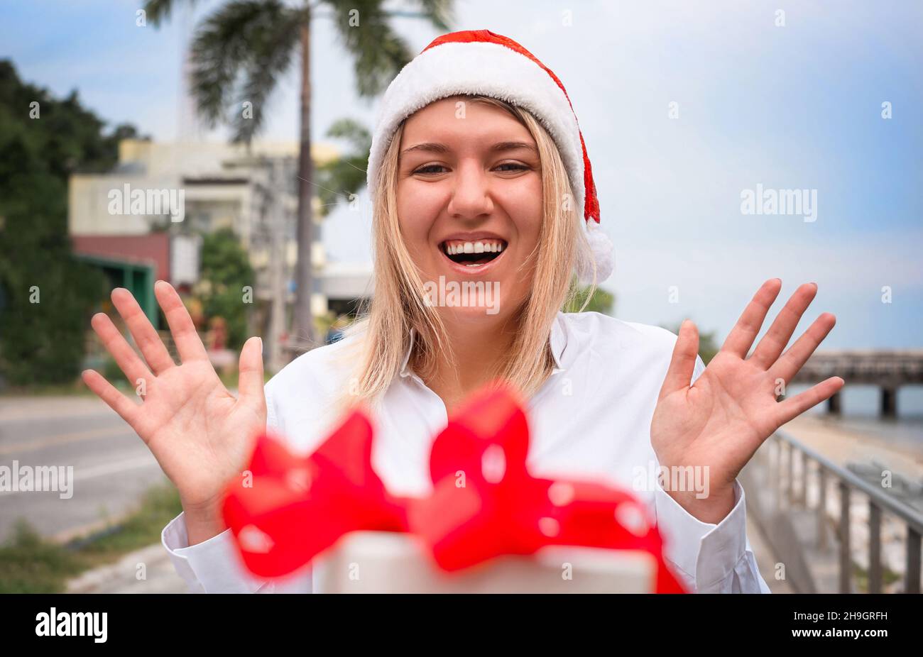 La ragazza nel cappello di santa sorprendente con scatola regalo di Natale Foto Stock