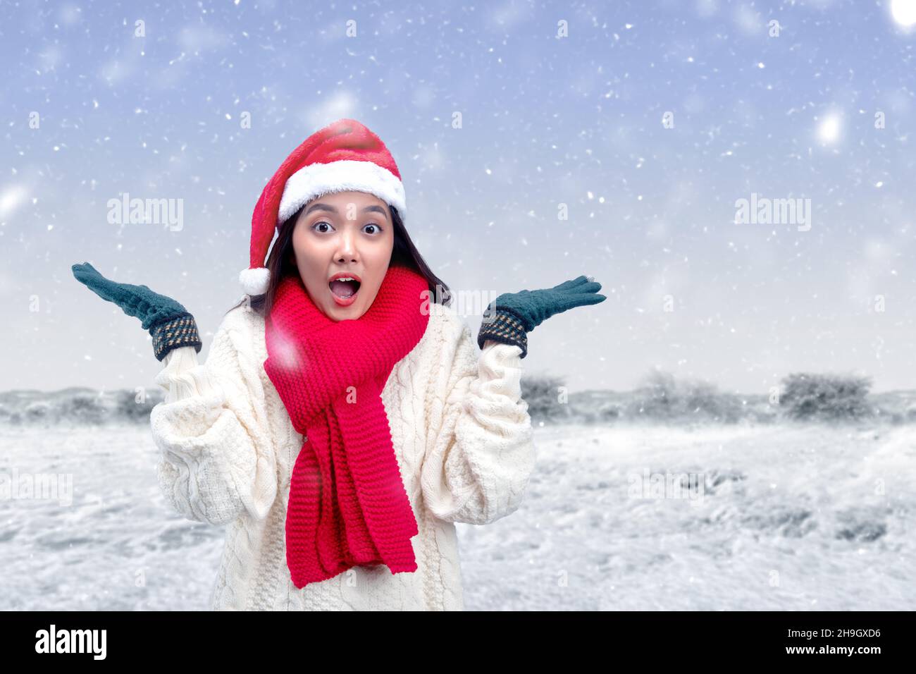 Donna asiatica con guanti invernali e cappello Santa in piedi sul