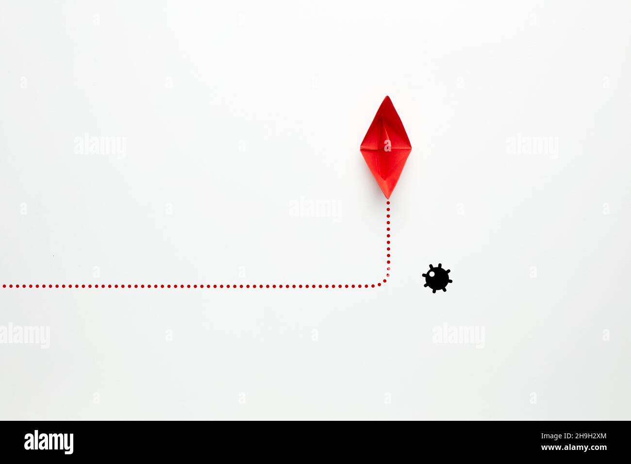 La barca di carta rossa cambia direzione contro una miniera navale su sfondo bianco. Rischi, minacce o rischi da evitare nel concetto aziendale. Foto Stock