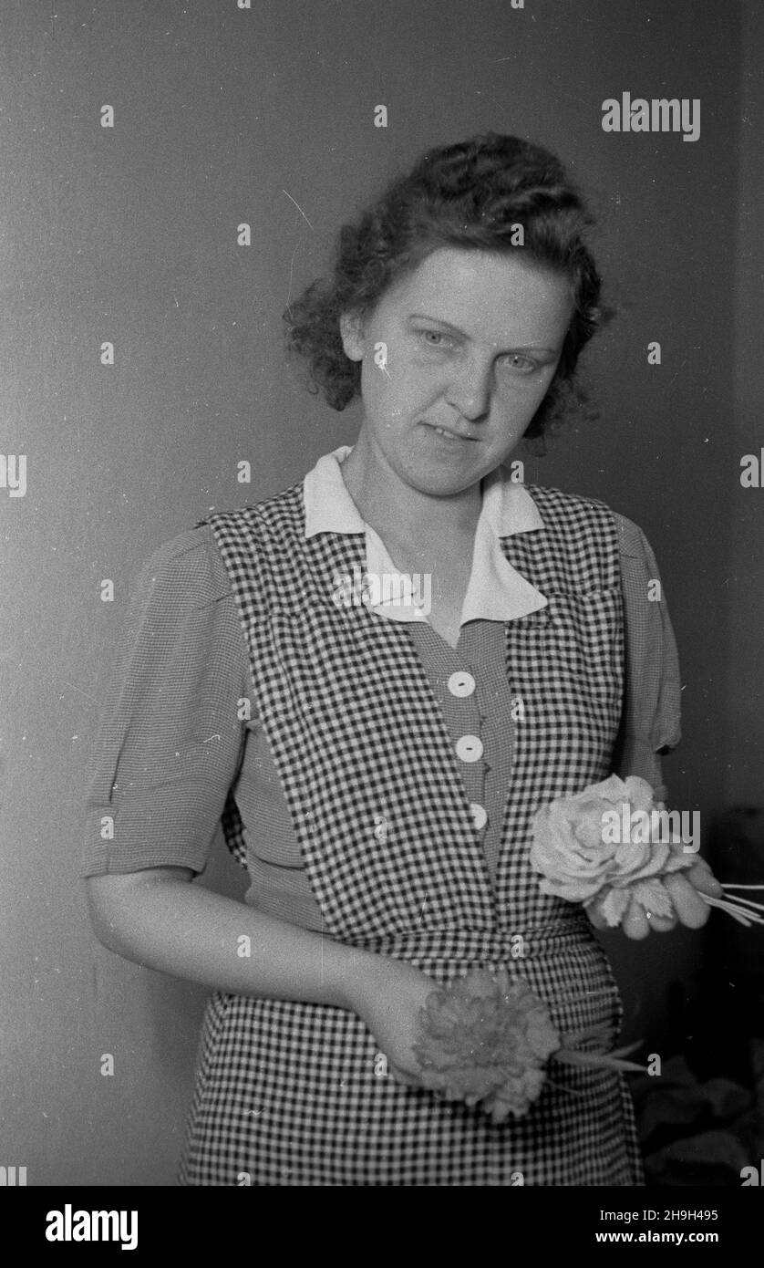 Warszawa, 1948-07. Liga Kobiet zorganizowa³a od czerwca 1947 r. 144 kursy kszta³cenia zawodowego dla 5750 kobiet. Uczy³y siê m.in.: gorseciarstwa, kwiaciarstwa, zegarmistrzostwa, zabawkarstwa. Uzestniczka kursu robienia kwiatów ze szmatek, nauka trwa 4 miesi¹ce. mw PAP Dok³adny dzieñ wydarzenia nieustalony. Varsavia, luglio 1948. Dal giugno 1947 la Women's League ha organizzato 144 corsi professionali per 5,750 donne. I corsi hanno insegnato corsetta, floristry, orologiaio, fabbricazione di giocattoli. Nella foto: Un partecipante a un corso di 4 mesi per la produzione di fiori artificiali. mw PAP Foto Stock