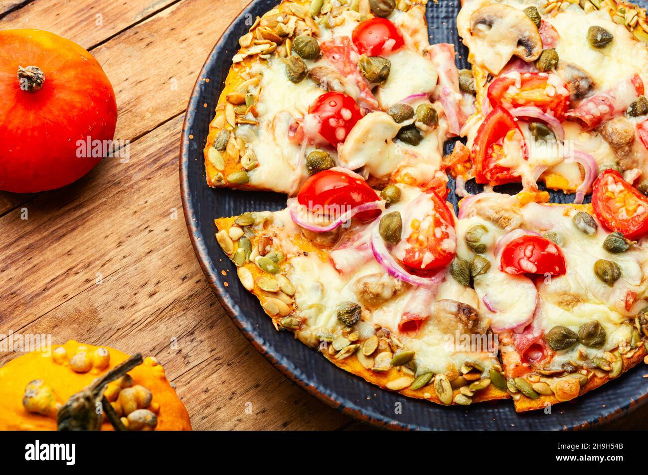 Pizza con salsiccia, pomodoro e capperi su una tortilla di zucca Foto Stock