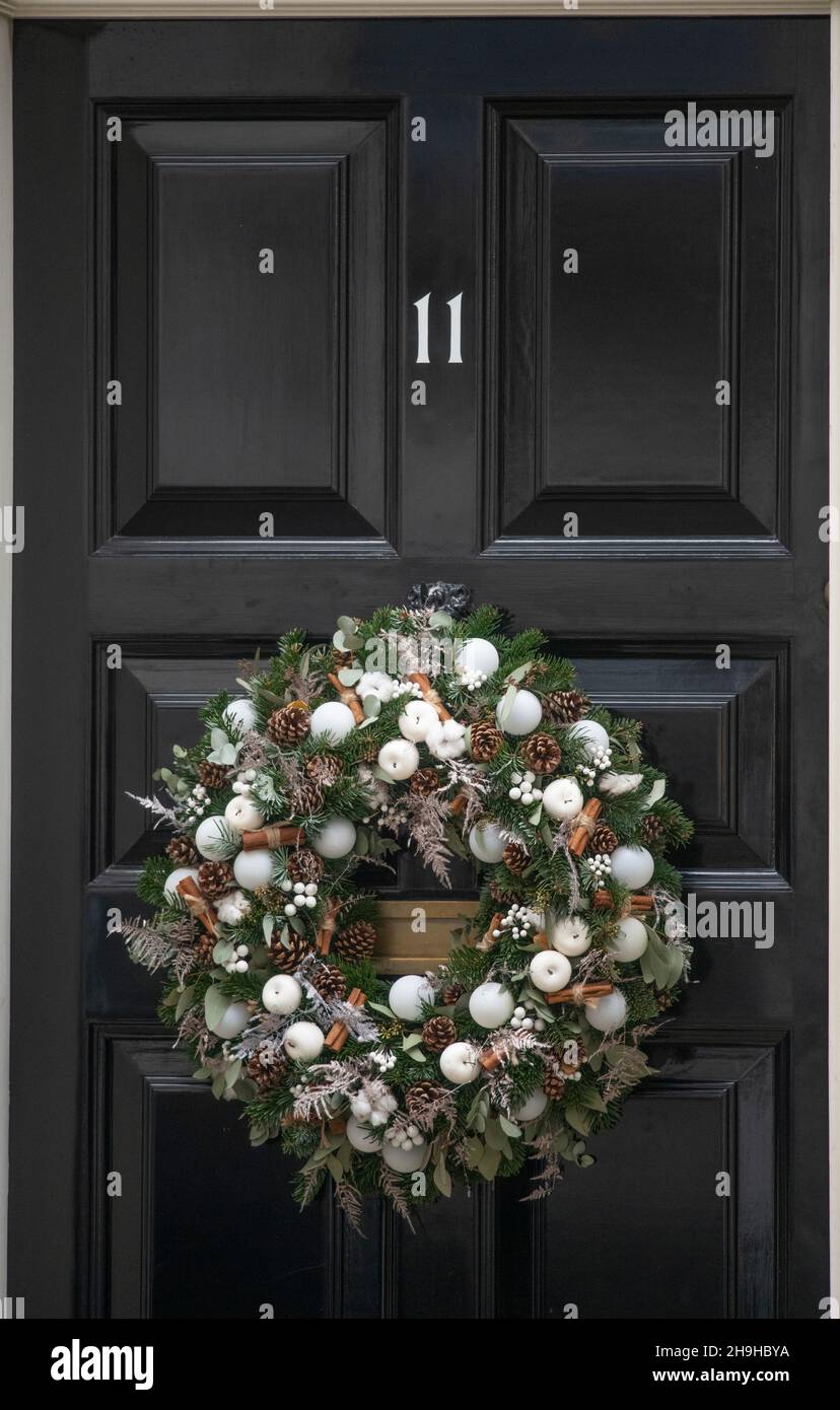 Downing Street, Londra, Regno Unito. 7 dicembre 2021. Corona di Natale sulla porta d'ingresso del 11 Downing Street, casa del Cancelliere britannico dello scacchiere. Credit: Malcolm Park/Alamy Foto Stock