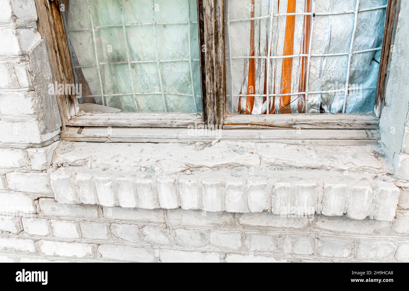 Parte inferiore di telaio di finestra di legno curvato con materiale sporco in un muro di mattoni Foto Stock