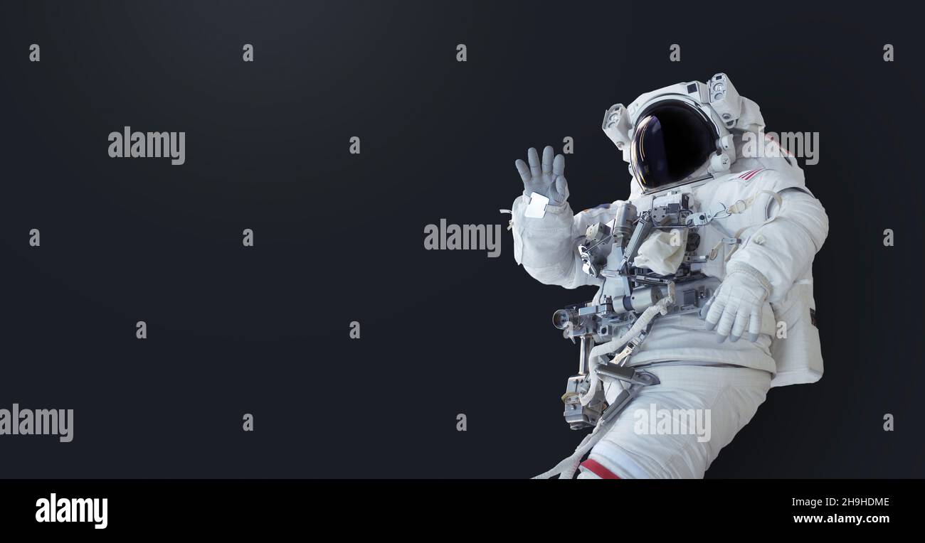 Spaceman su sfondo isolato scuro. Carta da parati con l'astronauta. Spazio uomo con copyspace per testo e design Foto Stock