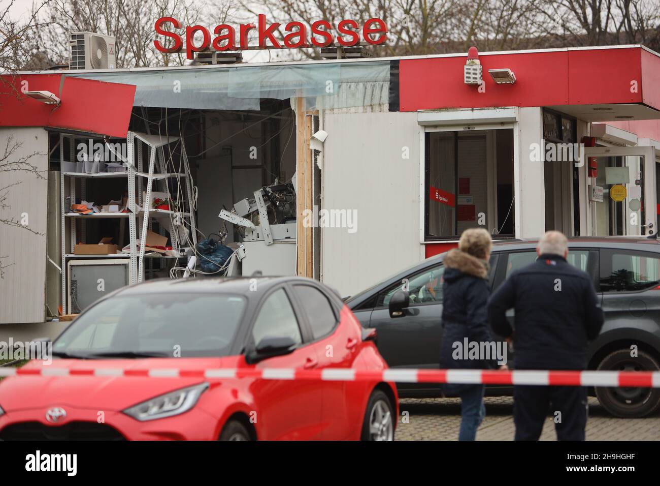 Wasserleben, Germania. 7 dicembre 2021. I dipendenti della cassa di risparmio visitano la scena di un'esplosione ATM. Un bancomat era stato distrutto in un'esplosione. Gli autori sconosciuti avevano introdotto una miscela di gas nell'ATM e scatenato un'esplosione. Il bancomat è stato completamente distrutto e anche l'edificio è stato notevolmente danneggiato. Credit: dpa/dpa-Zentralbild/dpa/Alamy Live News Foto Stock