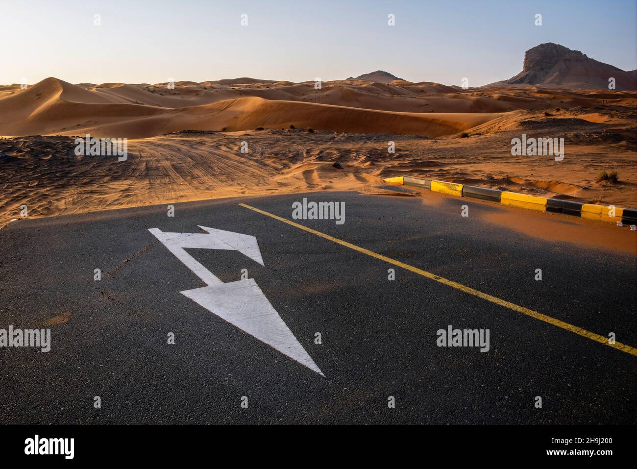 La fine della strada asfaltata a Mleiha con vista verso Fossil Rock, Sharjah, Emirati Arabi Uniti Foto Stock