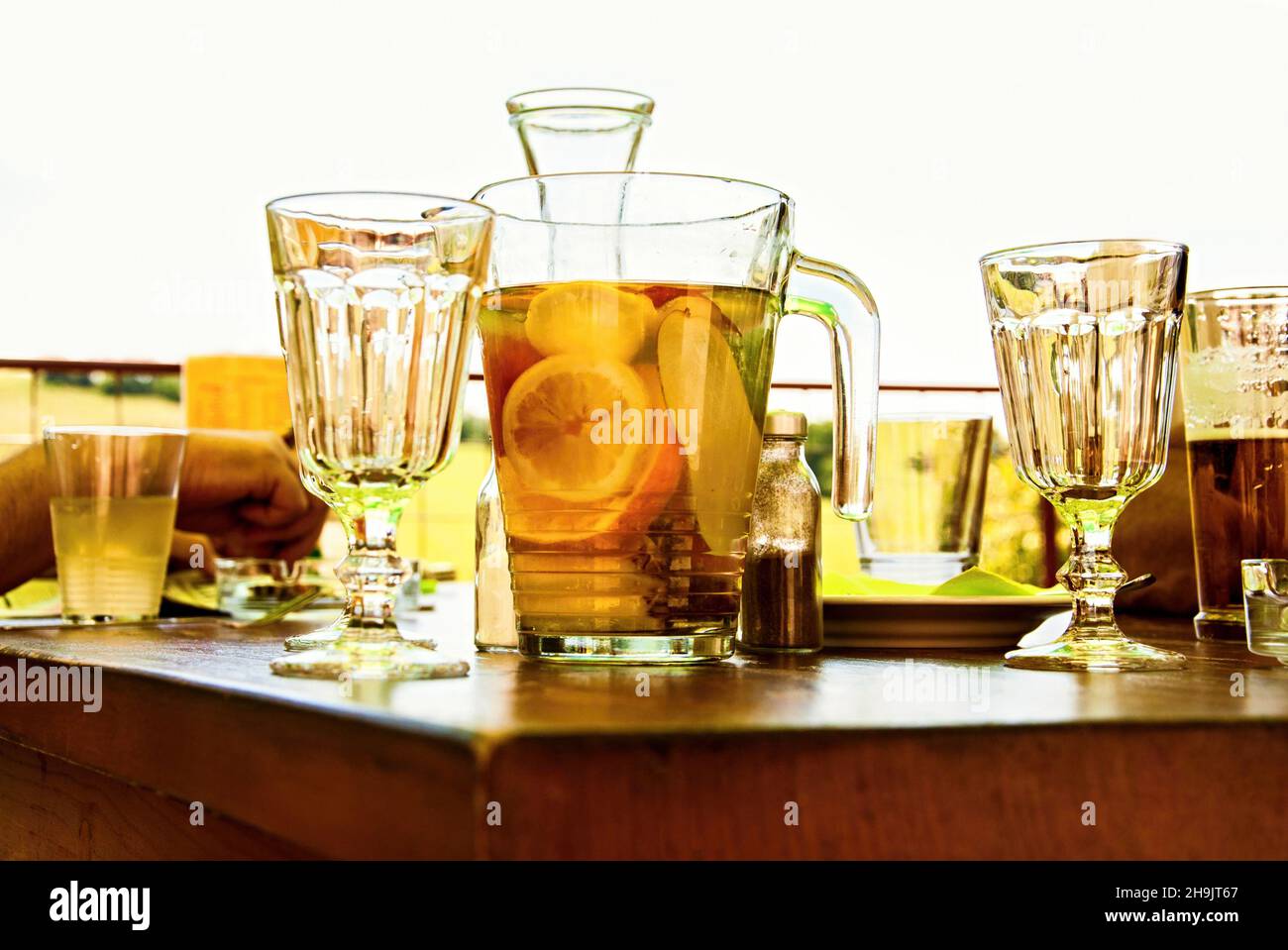 Molti bicchieri e caraffa con limonata di frutta (arancio, limone, pera) sul tavolo. Foto Stock