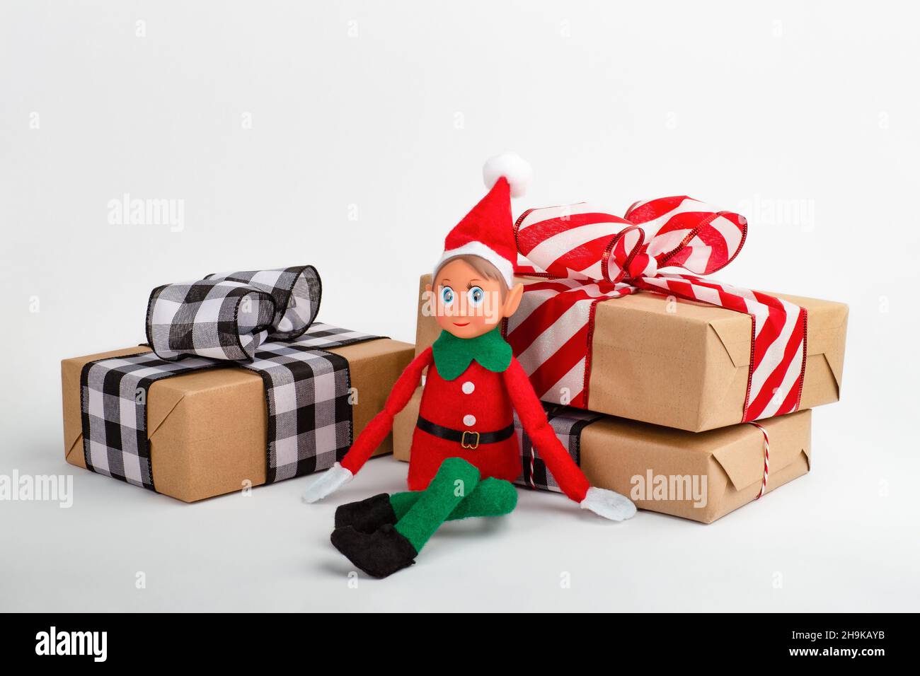 Giocattolo Elf di Natale con scatole regalo su sfondo bianco con spazio per la copia. Lo spirito di Natale, la tradizione di famiglia di Natale. Foto Stock
