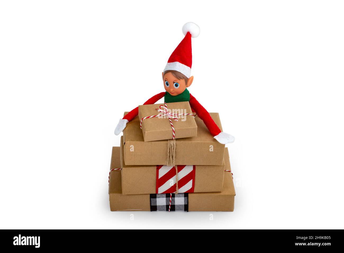Elf di Natale su una pila di scatole regalo su uno sfondo bianco isolato con spazio copia. Lo spirito di Natale, la tradizione di famiglia di Natale. Foto Stock
