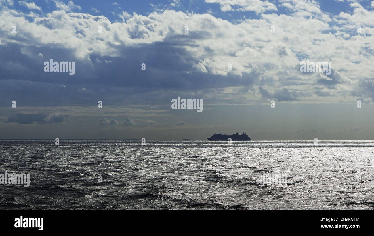 Silhouette di una nave da crociera che naviga lungo l'orizzonte. Foto Stock