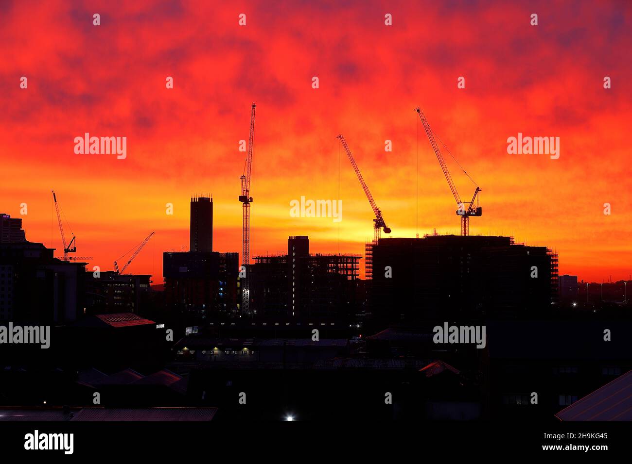 Un bel cielo rosso al mattino dietro gli appartamenti Junction attualmente in costruzione nel centro di Leeds Foto Stock