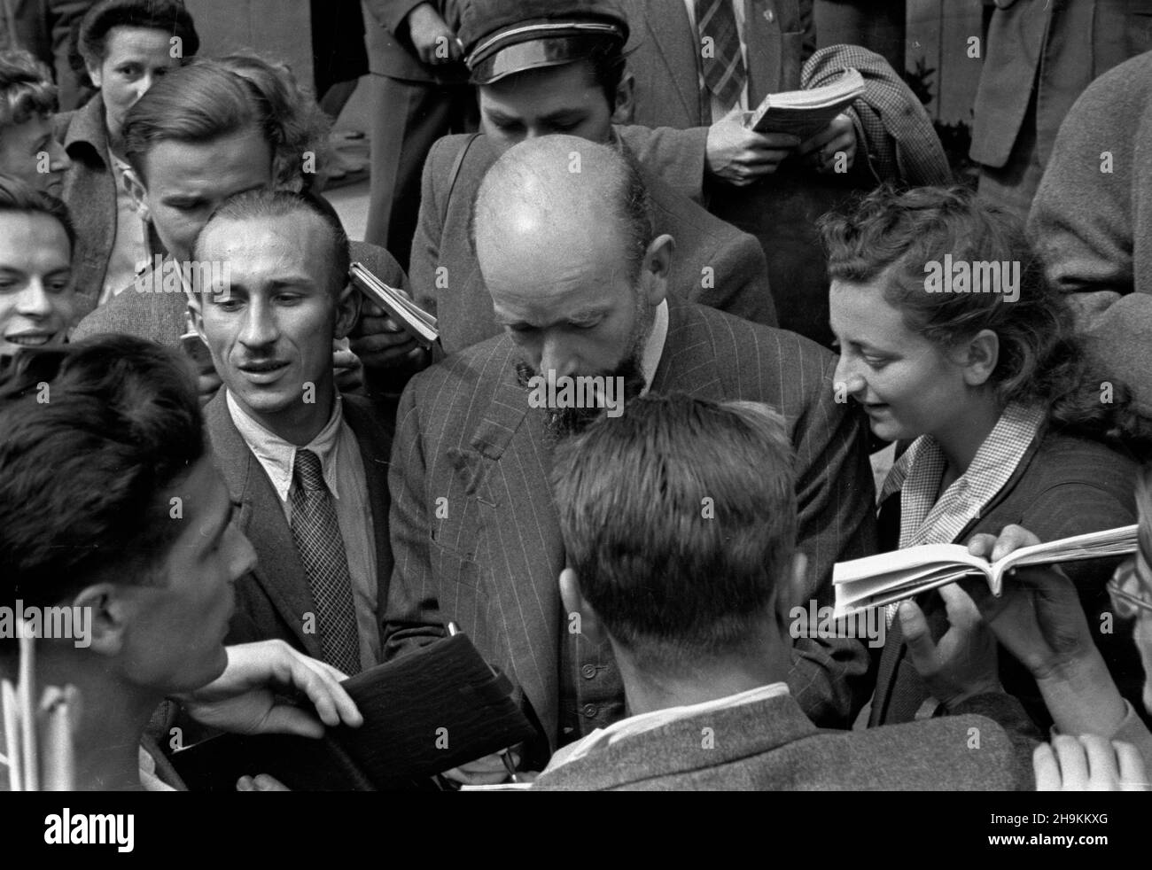 Wroc³aw, 1948-08-28. W dniach od 25 do 28 sierpnia odbywa³ siê Œwiatowy Kongres Intelektualistów w obronie Pokoju. NZ. Delegat kongresu rozdaje autografa gmachem przed Politechniki Wroc³awskiej. msa PAP Wroclaw, 28 agosto 1948. Il Congresso Mondiale degli intellettuali in Difesa della Pace si è tenuto dal 25 al 28 agosto. Nella foto: Un delegato al Congresso che dà autografi di fronte alla Wroclaw Technical University. msa PAP Foto Stock