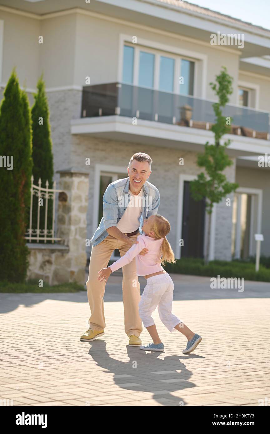 Papà divertirsi con sua figlia e sentirsi impressionante Foto Stock