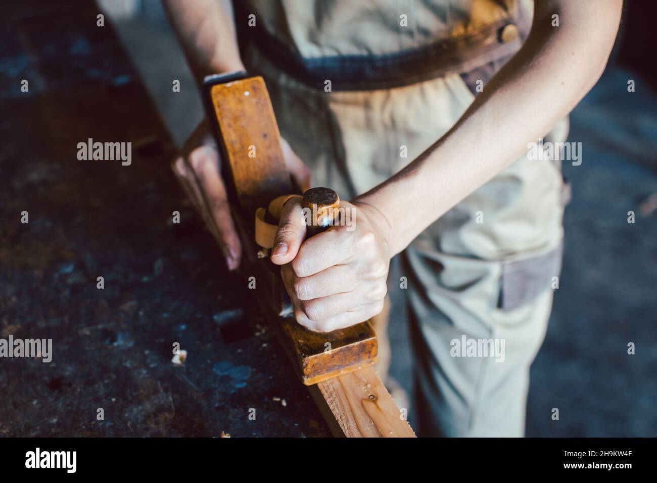 Primo piano su mano di falegname donna con piallatrice di legno Foto Stock