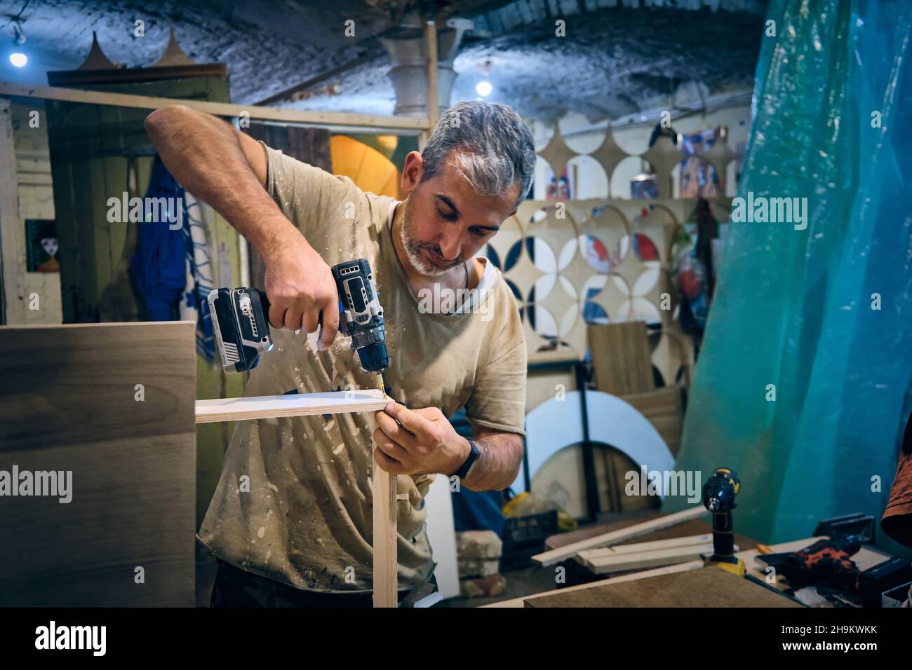 Man fissa legno compensato con viti Foto Stock