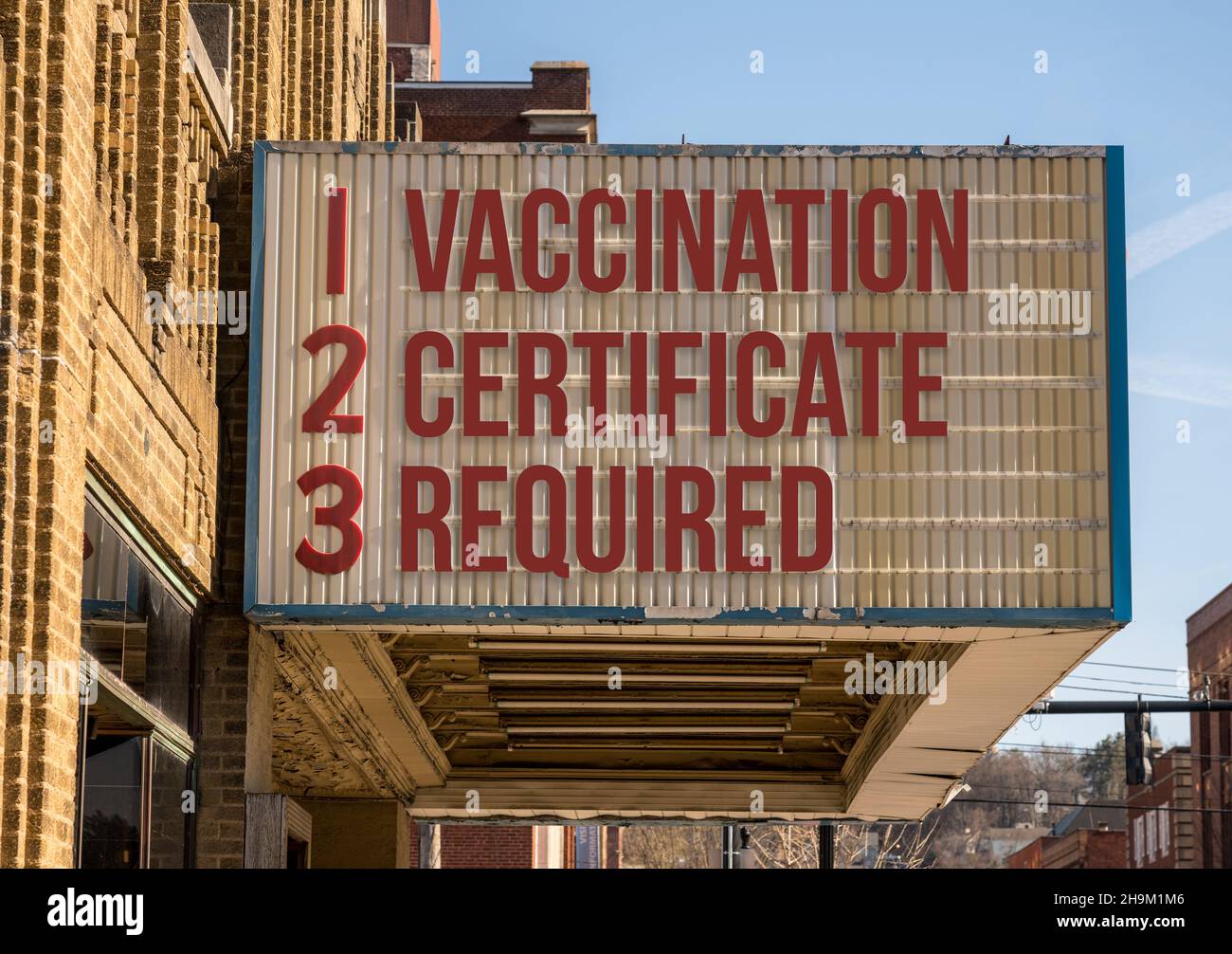 Mockup di cinema cartellone con mandato di vaccinazione per l'ingresso nelle aree pubbliche durante il coronavirus o l'epidemia di Covid-19 Foto Stock