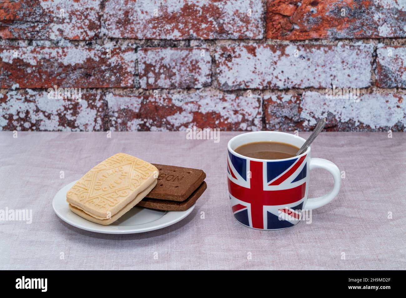Tazza inglese stampata con una bandiera UK Union Jack con crema pasticcera e biscotti borbonici al cioccolato Foto Stock