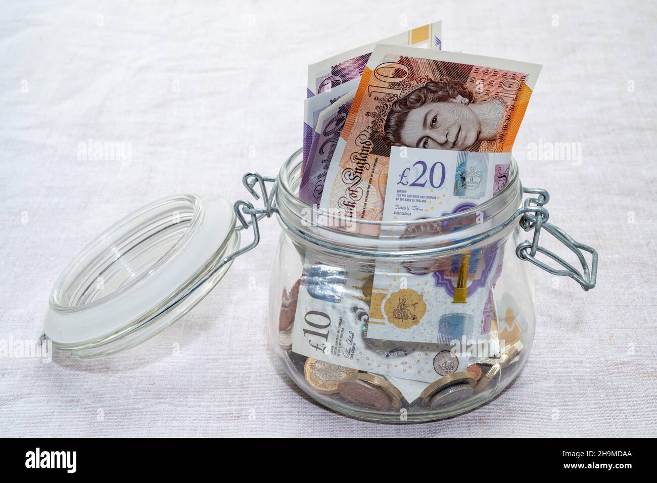 Denaro britannico immagazzinato in un vaso di vetro Foto Stock