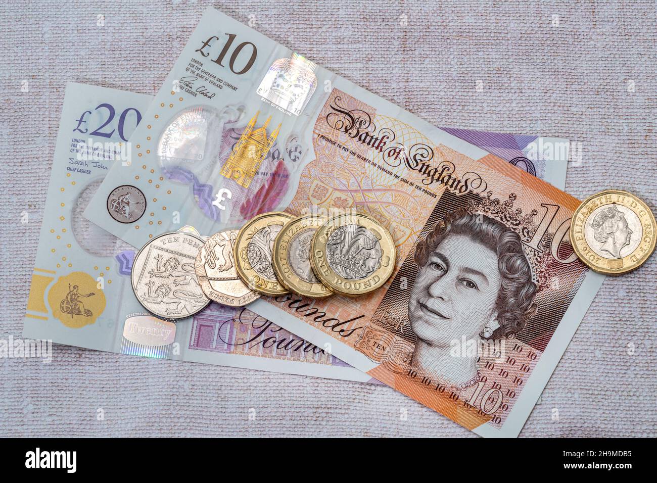 British Bank of England una banconota da venti sterline con alcune monete. Foto Stock