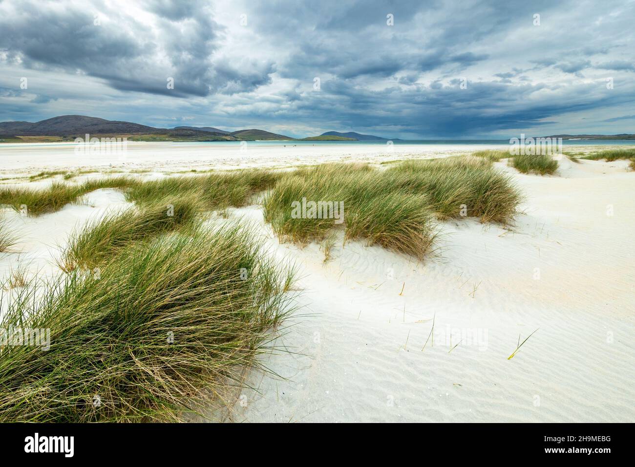 Nuvoloso si affaccia sull'erba delle dune di marram e sulla spiaggia di Luskenthire sulla remota isola Ebridea di Harris nelle Ebridi esterne, Scozia, Regno Unito Foto Stock