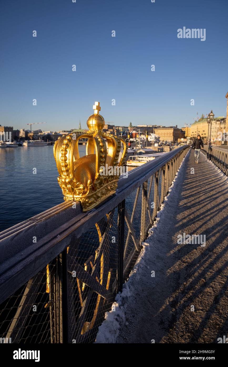 Stoccolma in inverno. Corona dorata su Skeppsholmsbron con Strandhagen sullo sfondo. Foto Stock