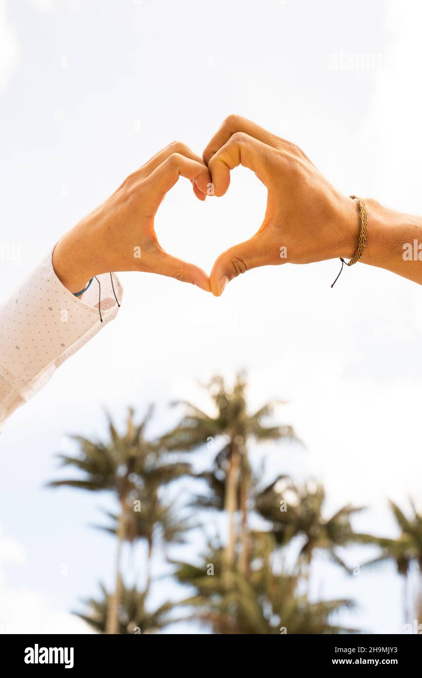 Le mani si uniscono formano un cuore, simbolo dell'amore. Foto Stock