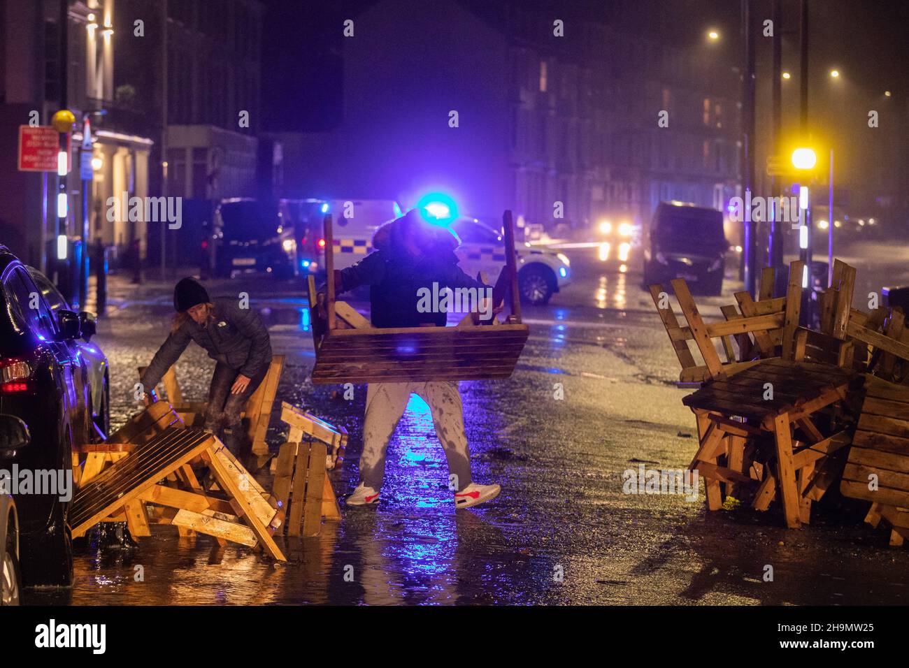 Aberystwyth, Ceredigion, Galles, Regno Unito. 07th December 2021 UK Weather: Mobili da un caffè sul mare viene spazzato lungo la strada sul lungomare di Aberystwyth durante la tempesta barra stasera ad Aberystwyth. © Ian Jones/Alamy Live News Foto Stock