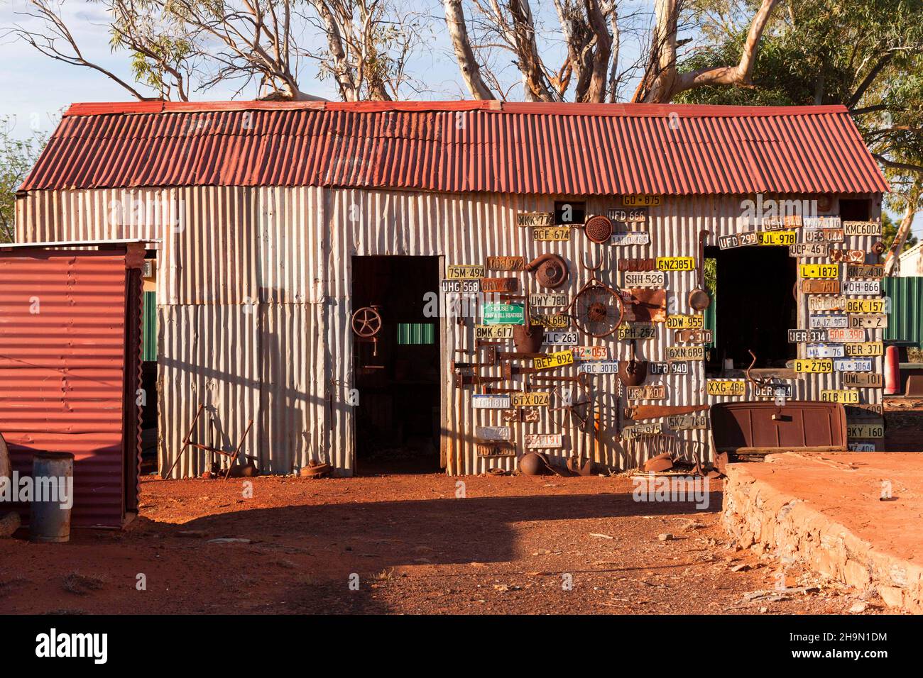 Capanna di ferro corrugato coperta di targhe per veicoli, nella storica città mineraria dell'oro di Gwalia, Leonora, Australia Occidentale Foto Stock