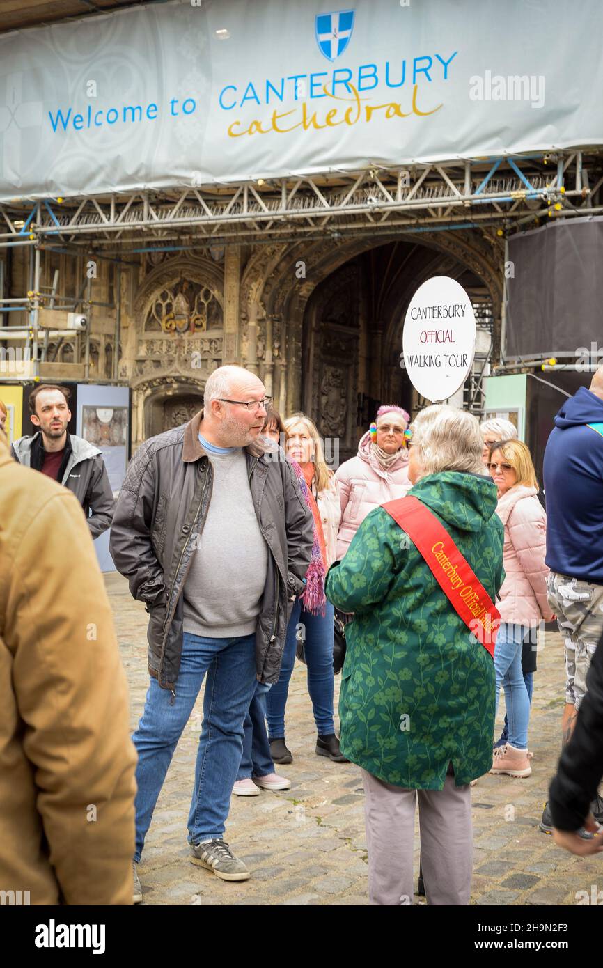 La guida ufficiale del tour a piedi di Canterbury si trova all'esterno della cattedrale di Canterbury con un gruppo di turisti. Foto Stock