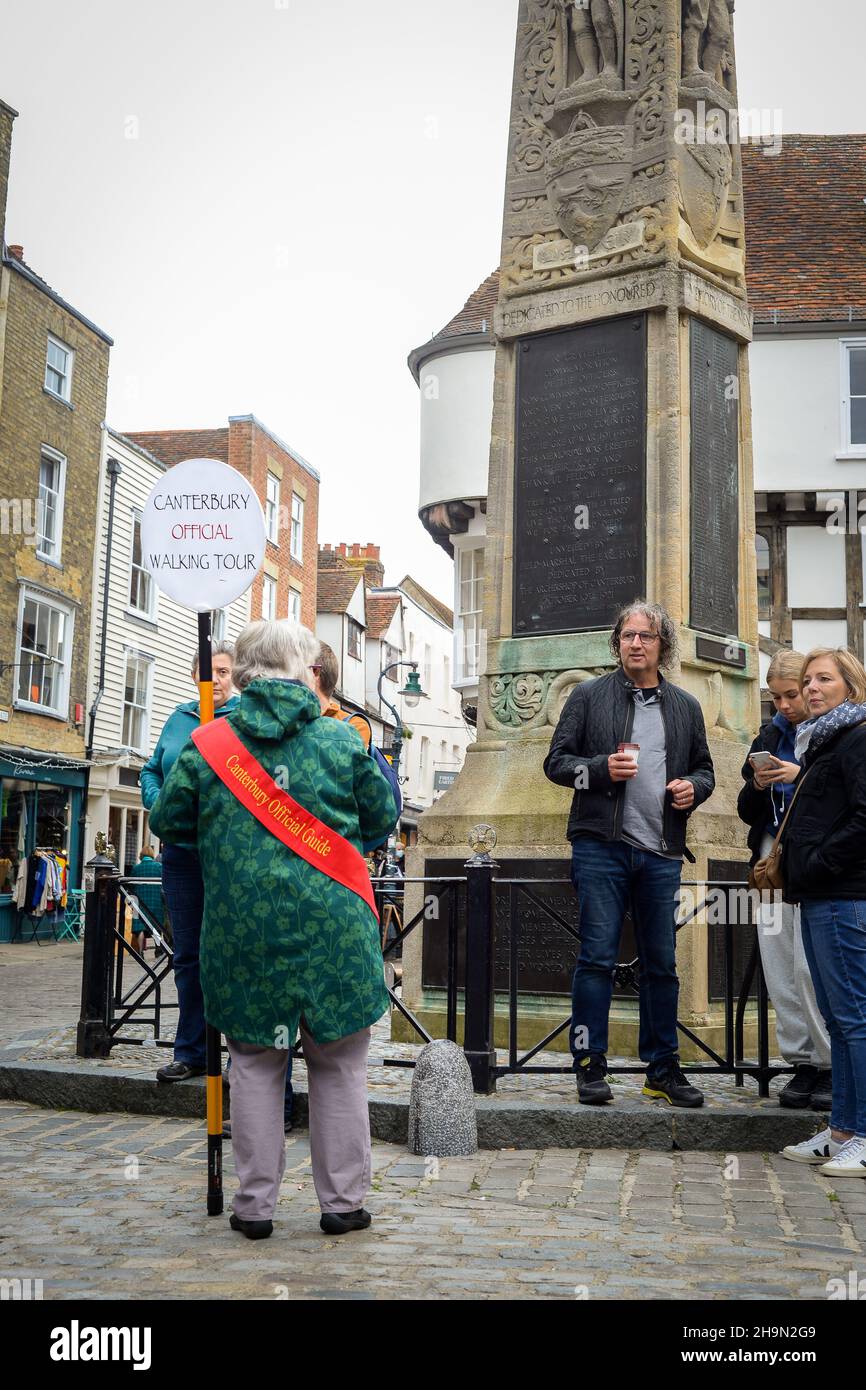 La guida ufficiale del tour a piedi di Canterbury parla a gruppi di turisti con il monumento commemorativo della guerra a Canterbury, Kent. Foto Stock