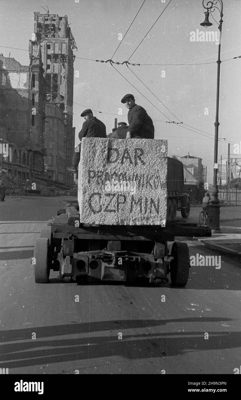 Warszawa, 1948-10-20. Zniszczona w styczniu 1945 r. Kolumna Zygmunta III Wazy zosta³a odbudowana z inicjatywy pracowników Pañstwowych Kamienio³omów. Trzon kolumny wykuto z 30-tonowego bloku granitowego o d³ugoœci 10 metrów, wydobytego w kamienio³omie ¯bik w Strzegomiu i przewiezonego kolej¹ do Warszawy. Dalej transport odbywa³ siê na specjalnej lawecie, której obs³ugê stanowili robotnicy firmy C. Hartwig: Zaj¹c, Glinka, Janke, Czy¿ewski, Dembowski, Wnuk i Kisiel. NZ. Kolumna transportowa na placu Napoleona (Powstañców Warszawy). Z lewej wypalony budynek Towarzystwa Ubezpieczeñ Prudential. pw Foto Stock