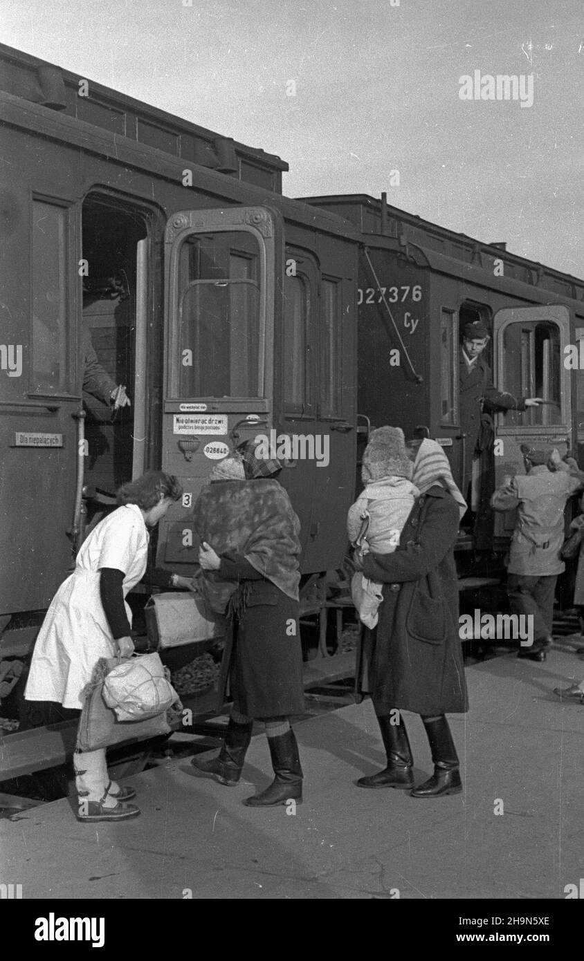 Warszawa, 1948-11. Dworzec Warszawa G³ówna Osobowa. Pielêgniarka z prowadzonej przez Ligê Kobiet Izby Dworcowej matki i Dziecka, pomaga podró¿uj¹cej matce wsi¹œæ do poci¹gu. Dok³adny dzieñ wydarzenia nieustalony. bk PAP Varsavia, novembre 1948. Warszawa Glowna Osobowa stazione ferroviaria. Un'infermiera del centro madre e bambino della stazione ferroviaria della lega delle donne che aiuta una madre in viaggio a salire su un treno. bk PAP Foto Stock