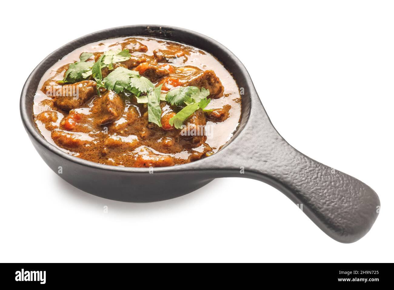 Padella con gustoso curry di manzo su sfondo bianco Foto Stock