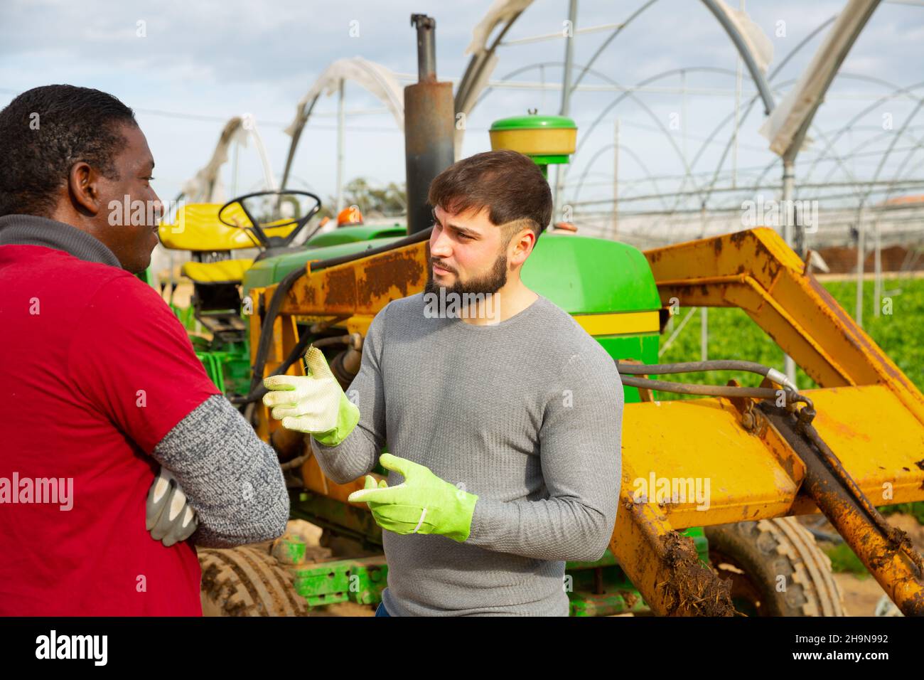 Giovane agricoltore che ha una conversazione spiacevole con il lavoratore Foto Stock