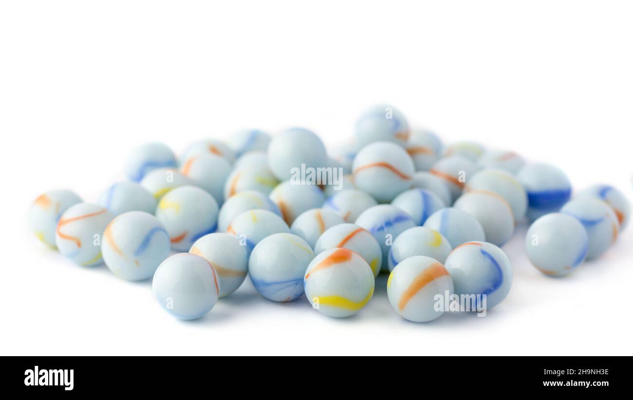 sfere di cristallo bianco bluastro, marmi colorati presi in profondità di campo poco profonda, isolati su sfondo bianco Foto Stock