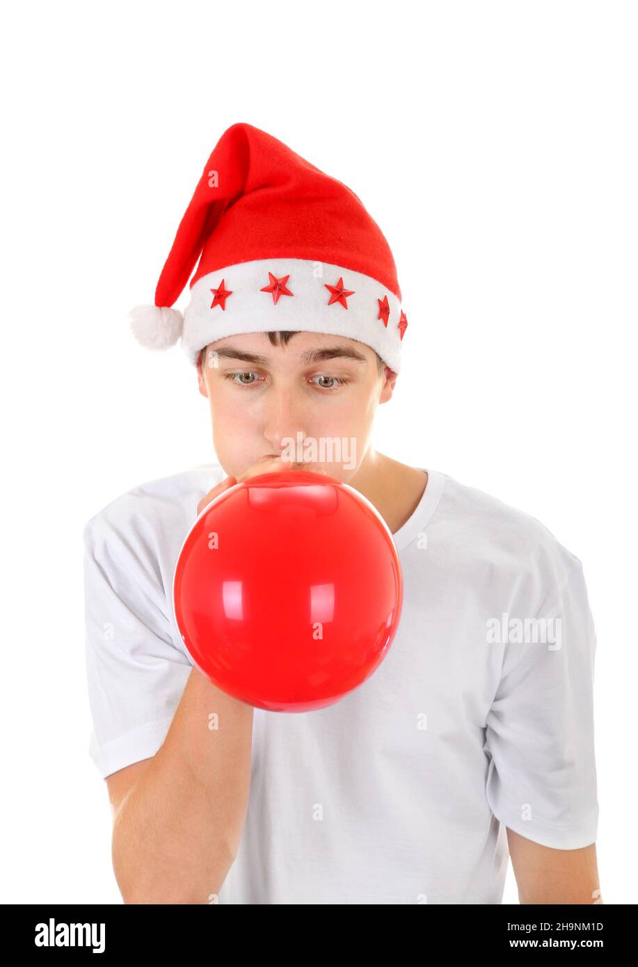 Adolescente in cappello di Babbo Natale gonfiare palloncino rosso isolato sullo sfondo bianco Foto Stock