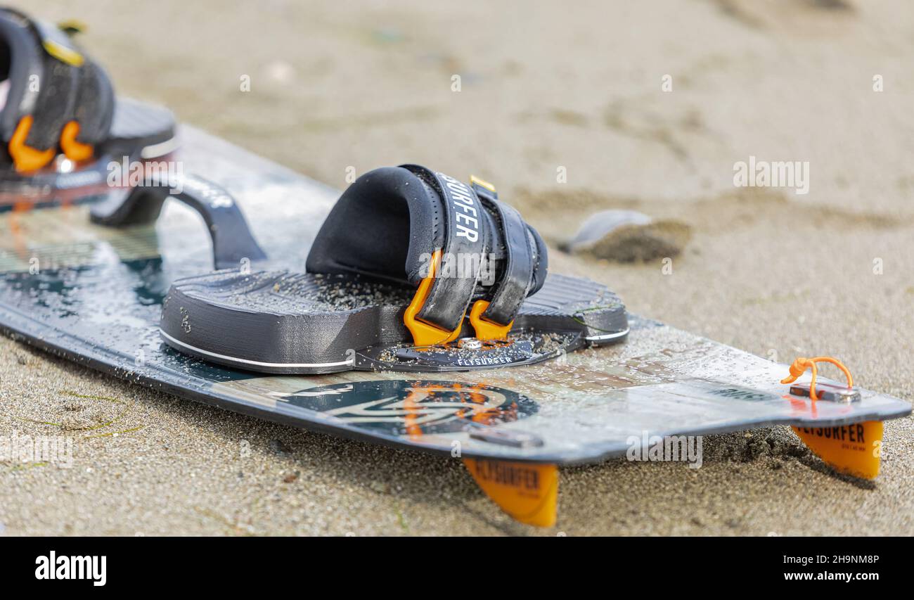 Kitesurfer preparare la sua attrezzatura in spiaggia. Primo piano surf board sulla sabbia Foto Stock