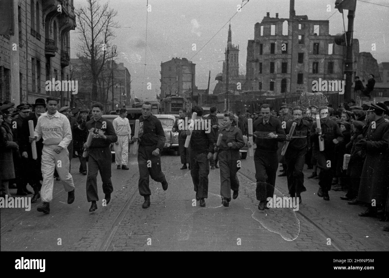 Warszawa, 1948-12-15. Okolicznoœciowa sztafeta m³odzie¿y z okazji i Zjazdu Polskiej Zjednoczonej Partii Robotniczej (PZPR). NZ. Uczestnicy biegu na ulicy Marsza³kowskiej, widok w stronê placu Zbawiciela. Od lewej: pierwszy przodownik pracy Powszechnej Organizacji S³u¿ba Polsce (700 proc. Normy) Bronis³aw Bujak, najlepszy uczeñ korpusu kadetów Korpusu Bezpieczeñstwa Wewnêtrznego (KBW) Maciej Janic, prymus Podoficerskiej Szko³y Piechoty Znik Koz³owski, przopprzánzánzánzka 1 Zprzánzka cz³onek zarz¹du wojewódzkiego Zprzprzánzánzka Wiœ Zprzánzánzánzánzka Zprzánzánzánzánzka Zprz Foto Stock