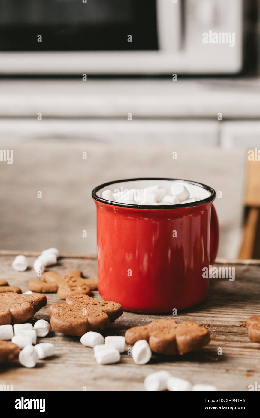 coppa rossa con cacao e marshmallows da vicino su sfondo di legno. Biscotti di Natale e altri dolci con cacao Foto Stock