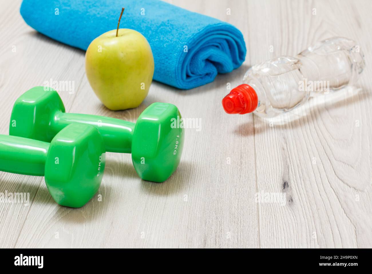 Manubri e diversi strumenti per il fitness sul pavimento in camera. Foto Stock