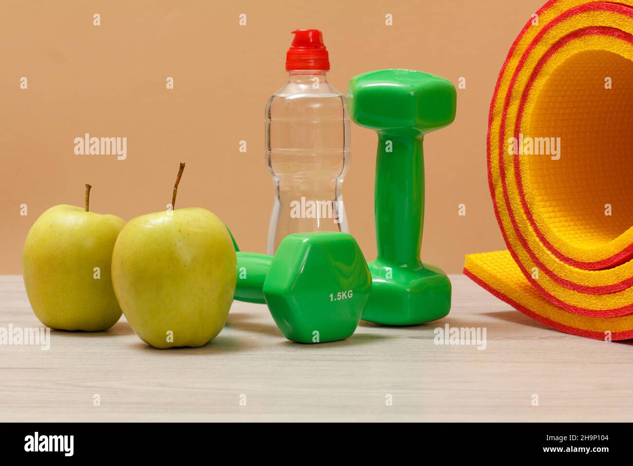 Manubri e diversi strumenti per il fitness sul pavimento in camera. Foto Stock