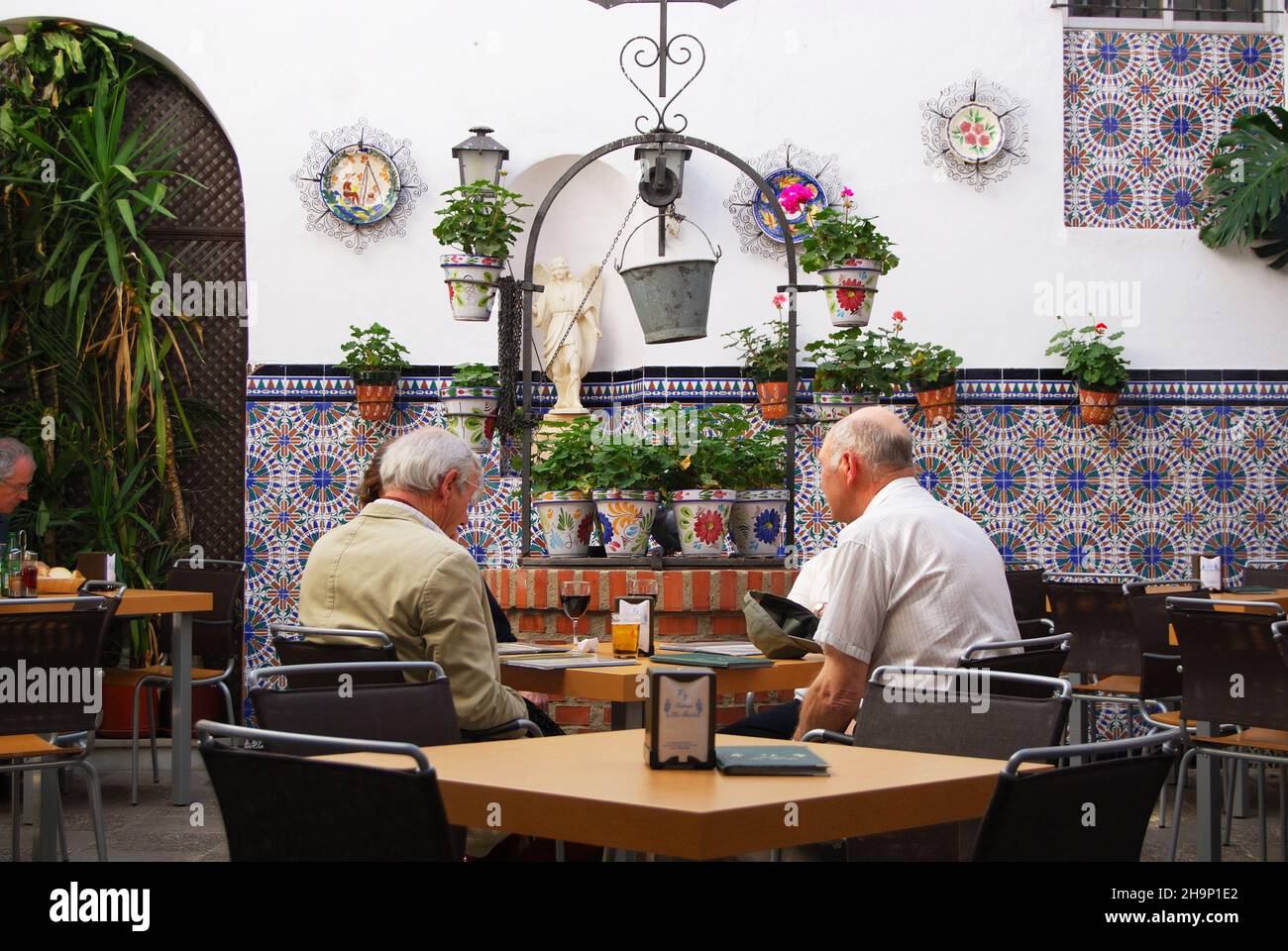 Anziani seduti in un cortile cafè, Cordoba, Spagna. Foto Stock