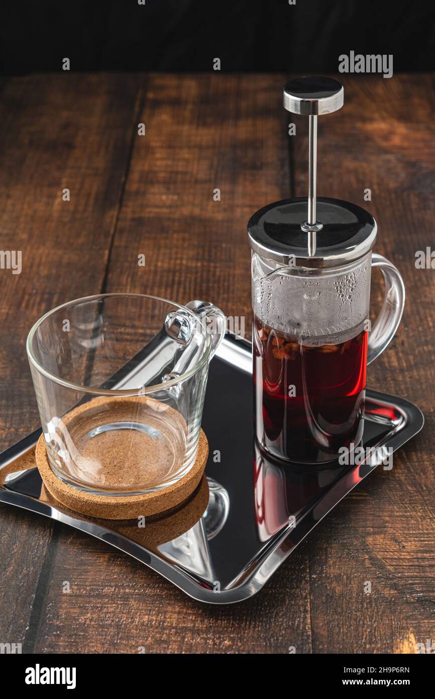Caldo tè invernale servito con una pressa francese su un pavimento in legno Foto Stock