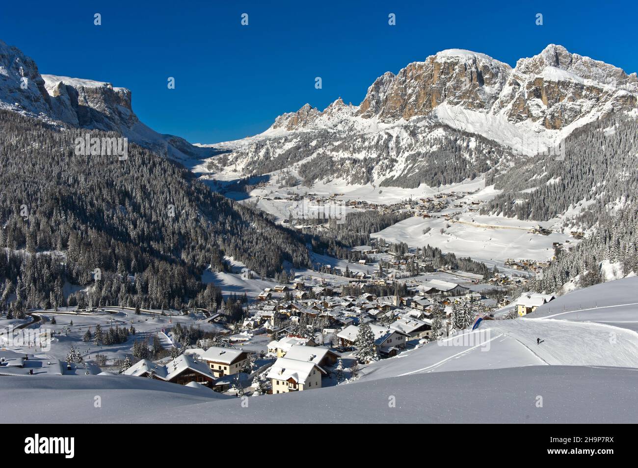 Villaggio montano di la Villa di fronte alle vette innevate delle Dolomiti, nel comprensorio sciistico dell'alta Badia, Dolomiti, Alto Adige, Italia Foto Stock