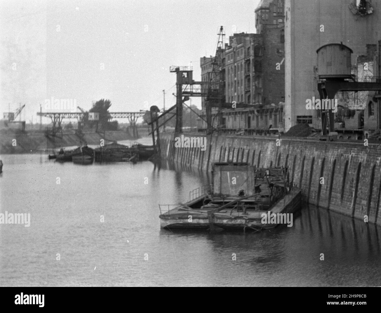 Wroc³aw, 1949-02. Port Miejski wraz z przyleg³¹ infrastruktur¹ zbudowano w latach 1897-1901 na Kleczkowie. NZ. kana³ portowy od strony wschodniej. Na nabrze¿u m.in. Magazyn portowy nr 2 (P). W tle ¿uraw prze³adunkowy. pw PAP Dok³adny dzieñ wydarzenia nieustalony. Wroclaw, febbraio 1949. Il Porto Municipale e le sue infrastrutture costruite a Kleczkow dal 1897 al 1901. Nella foto: Un canale portuale dal lato orientale. Sul molo n. 2 porto magazzino (a destra). Sullo sfondo una gru di ricarico. pw PAP Foto Stock