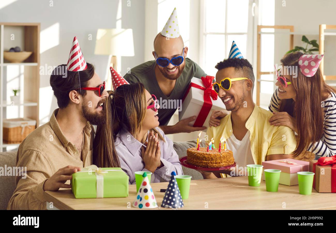 Festa di compleanno. Gli amici si congratulano con un uomo per il suo compleanno, gli danno una torta di compleanno. Foto Stock