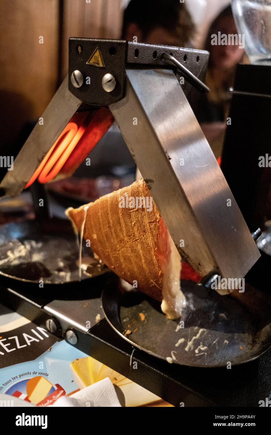 Ruota di formaggio raclette la fusione prima del camino Foto stock - Alamy