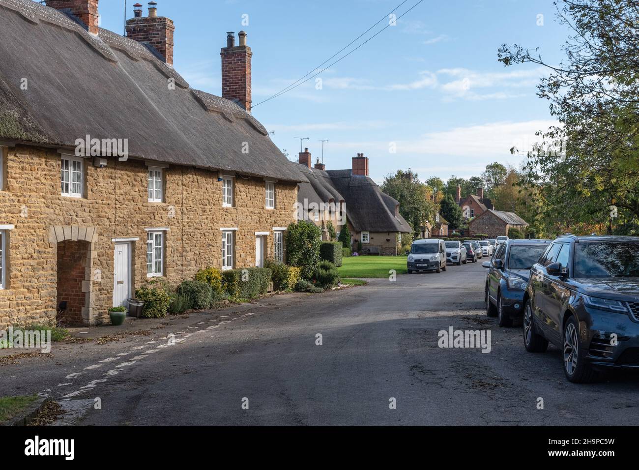 Scena stradale, con case di paglia, nel grazioso villaggio di Ashby St Ledgers, Northamptonshire, Regno Unito Foto Stock